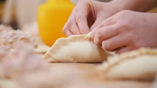 Cooks is Shaping Pies By Hands in the Bakery