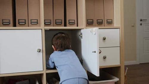 Toddler Exploring Shelving Unit in Home