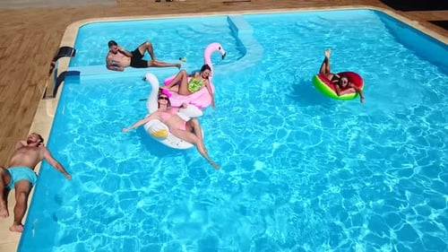 Aerial of Friends Having Party in Swimming Pool with Inflatable Flamingo Swan Mattress Happy Young