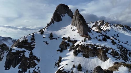 Montañas de Ciucas con parches de nieve bajo un cielo azul claro, principios de primavera, vista aérea