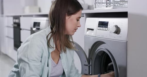 Woman Unloads Silver Washing Machine in Bright Laundry Room
