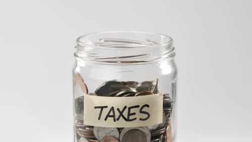 Coins Deposited into Taxes Jar Concept