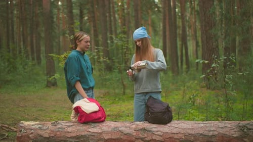Sisters Share Warm Drink in Tranquil Forest