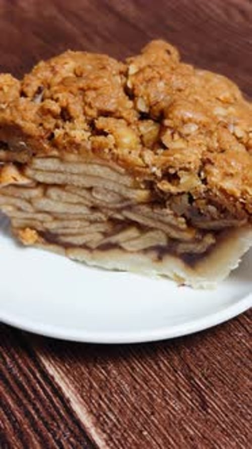 Delicious slice of apple crumble pie displaying a flaky crust, tender apple