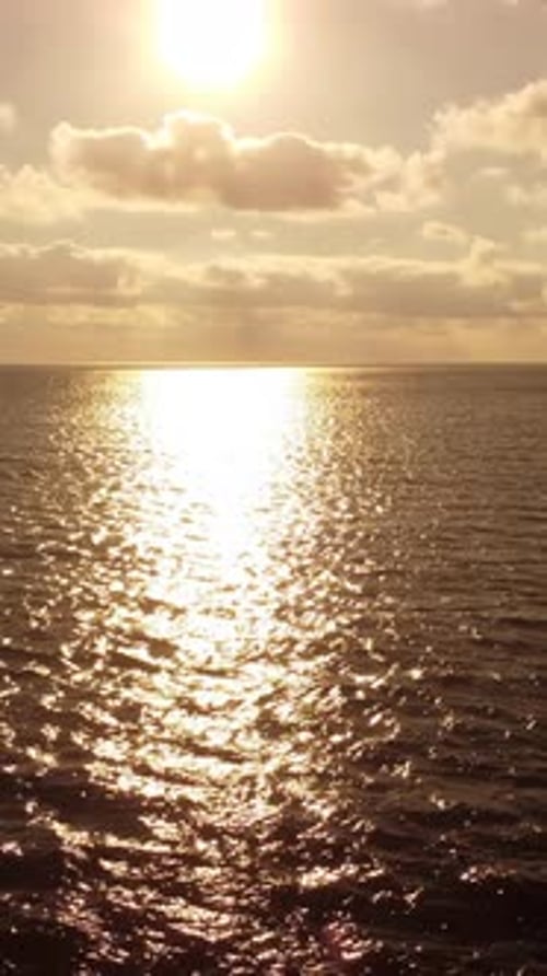 Sea Water Surface at Sunset Vertical Aerial View Camera Flies Over Calm Golden Sea Sun Glare