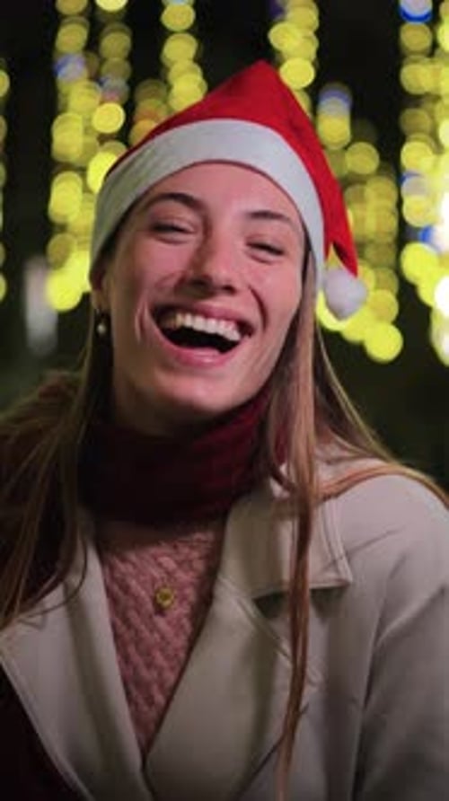 Smiling Woman Wearing Santa Hat in Christmas Lights