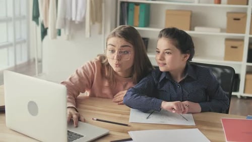 Woman Helping Child with Homework on Laptop