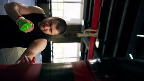 Vertikales Video in einem Boxkampf Club Senior-Muskeltrainer in einem schwarzen T-Shirt und mit