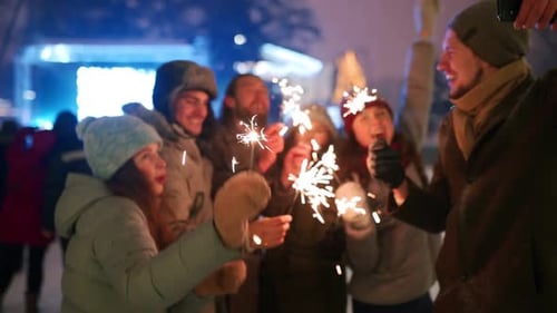Friends Have Fun Partying with Sparklers and Doing Selfie Photo on Smartphone at Christmas Market