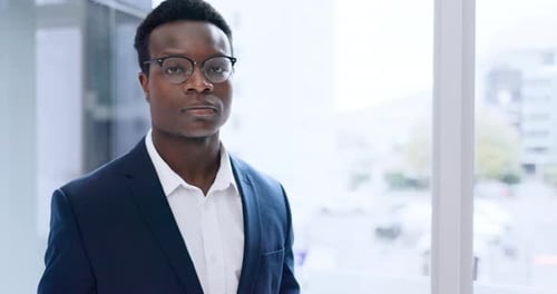 Face, corporate and a serious black man at a window in his office for professional work or career