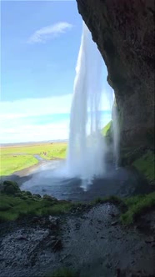 Majestätischer Wasserfall, der in den Fluss stürzt, von der Höhle aus gesehen