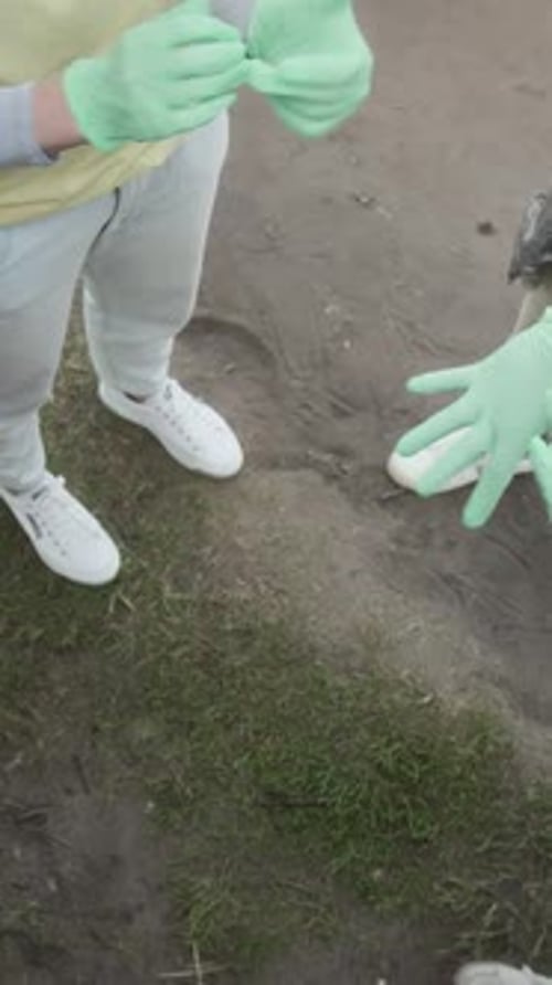People Putting Gloved Hands Together in Rural Setting