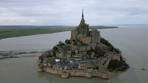Drone orbiting around Mont Saint Michel during low tide, Normandy in France. Aerial circling up
