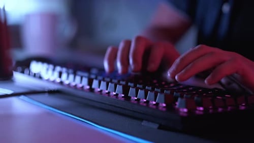 Hands Typing on a Glowing Computer Keyboard