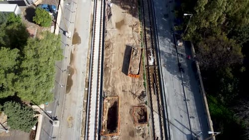 Foto aérea de un Zumbido de proa de una obra de construcción de tren ligero vacía en Jaffa, Israel, rodeada por d