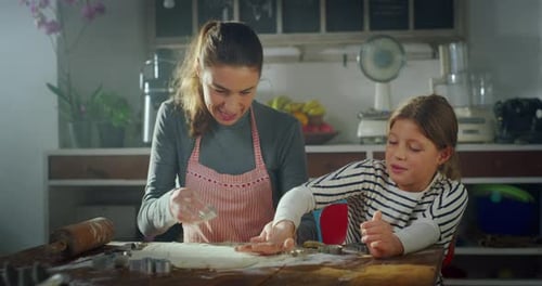 Mother and Child Cutting Cookies in Kitchen