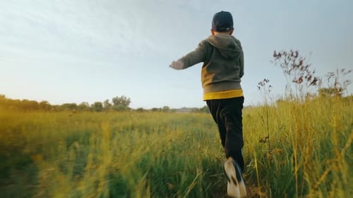 A Happy Child a Boy Runs Along the Green Grass Rejoices Laughs