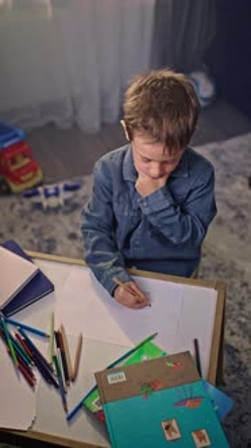Young Boy Engaged in Drawing with Colored Pencils Imaginative Play