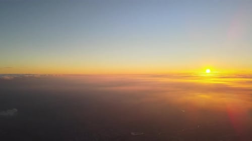 View From High Altitude of Bright Colorful Sunset Sky with Vivid Smooth Layer of Clouds Illuminated