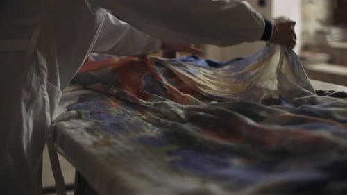 Italian seamstress prepares silk fabric in a sewing workshop in Italy