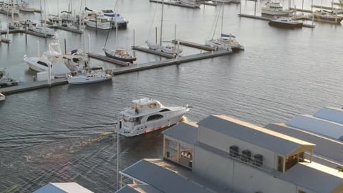 Motor Yacht For Charter Entering Marina During Golden Hour Of Sunset. - aerial