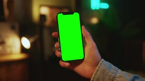 Hands Man Holding and Using Mobile Phone with a Vertical Green Screen Indoors Social Media Mock Up