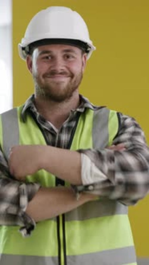 Smiling Construction Worker in Hard Hat Poses with Arms Crossed