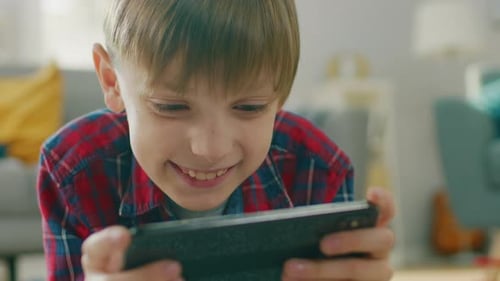 Happy Boy Focused on Playing Mobile Game