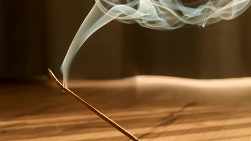 Incense Stick Emitting Swirls of Aromatic Smoke Indoors