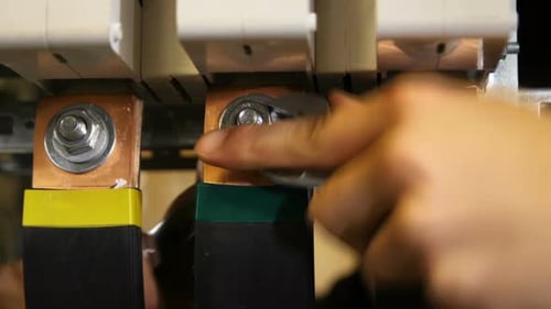 Technician Tightens Connections in Electrical Box