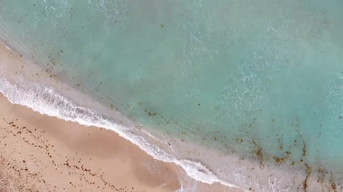 Luftaufnahme des smaragdgrünen Ozeans von Wellen am weißen Sandstrand