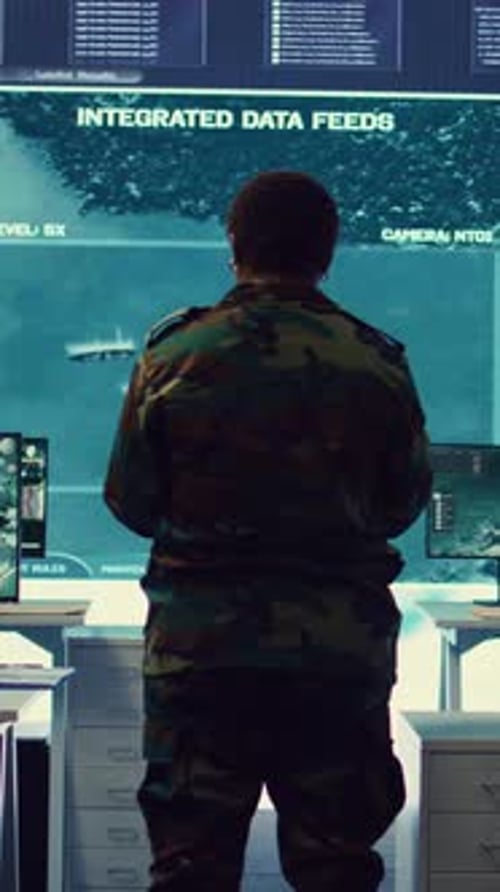 Soldier Stands at Computer Station Looking at Screen