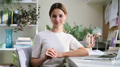 Smiling Woman Sitting at Desk in Home Office