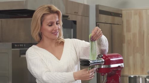 Woman Making Pasta With Pasta Maker in Kitchen
