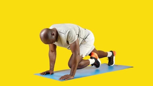 African Man Doing Mountain Climbers on a Mat