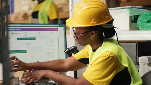 Woman scans packages at warehouse workstation
