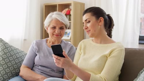 Senior Woman Learning Phone Use from Adult Daughter