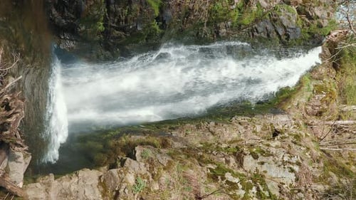Huge waterfall in forest with clear water falling down. Vertical video