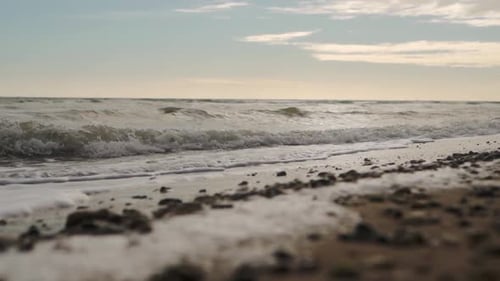 Slow Motion of Sea Waves Washing Northern Sandy Beach with Water and Foam Camera Moves Along Stormy