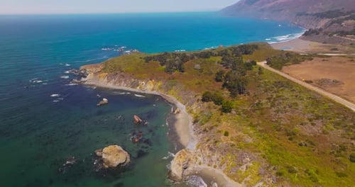 Rocky beach covered with moss, lichen and few bushes. Amazing coastline of Pacific at Morro Bay