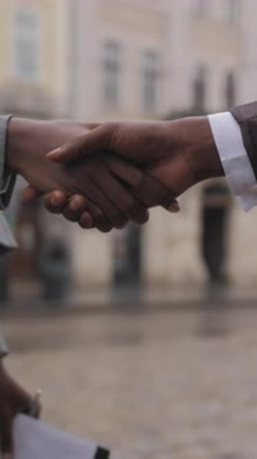 Close Up of Afro American Partners Shaking Hands Outdoors