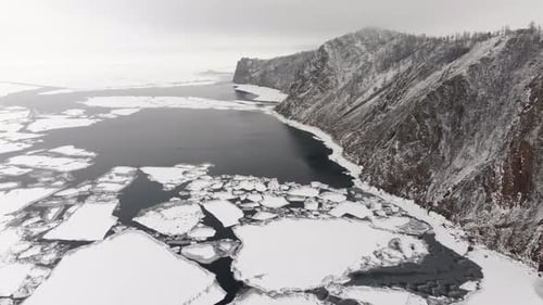 Aerial Landscape View Over Sea Ice Floes Covered in Snow at Overcast