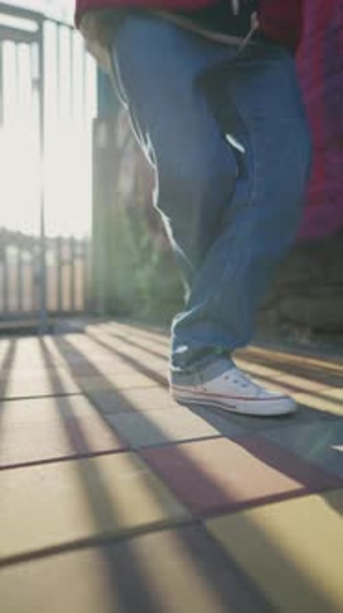 Male Legs in White Sneakers Dance Hip Hop on City Street in Sunlight