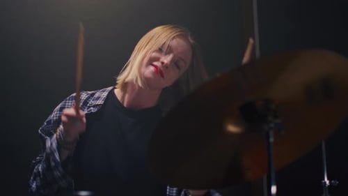 Girl Blonde Rock is Playing Drums on Concert Stage Woman Bangs on a Drum Kit Female Musician Bangs