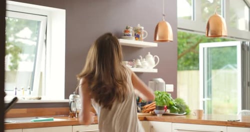 Happy Woman Dancing in the Kitchen at Home