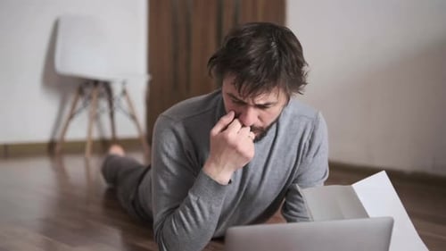 Man Paying Bills Online at Home Using Laptop and Documents Financial Management Remote Payment