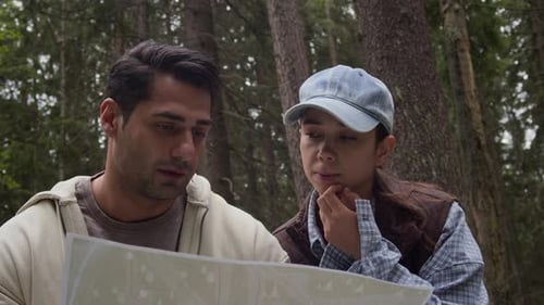Young Couple Navigating With Map in Forest