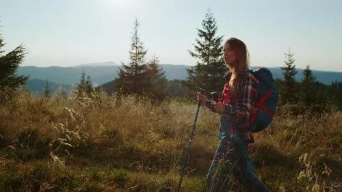 Woman Hiking Up Mountain with Trekking Poles
