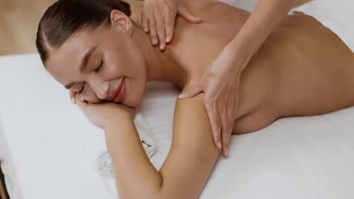 Relaxed Young Woman Having Healing Body Massage at Spa Salon Enjoying Relax Procedure Lying on