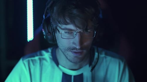 Young Adult Gamer Wearing Headset Smiles